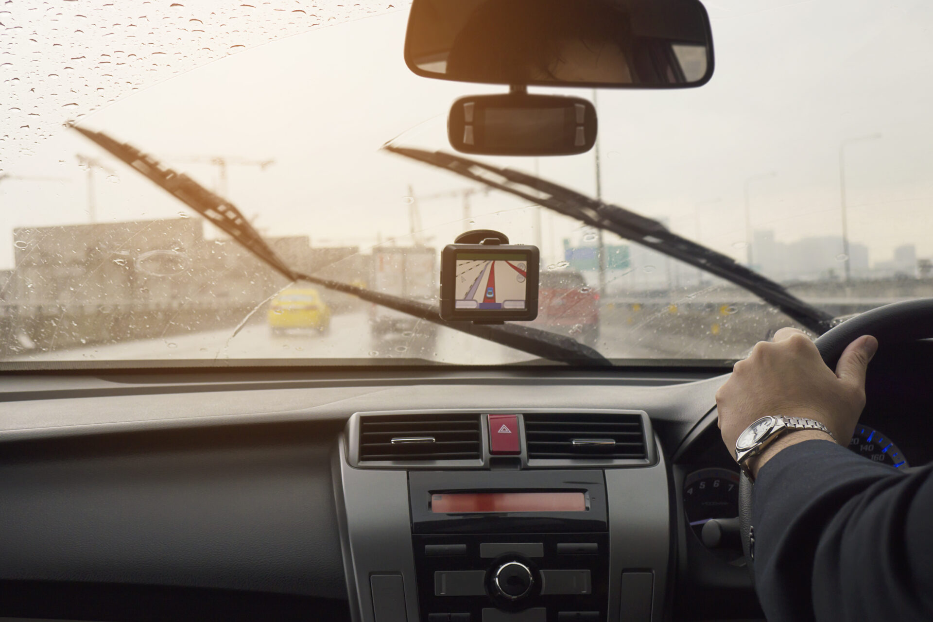 Business man is driving a car in raining day with moving wiper blades(Image by freepik )